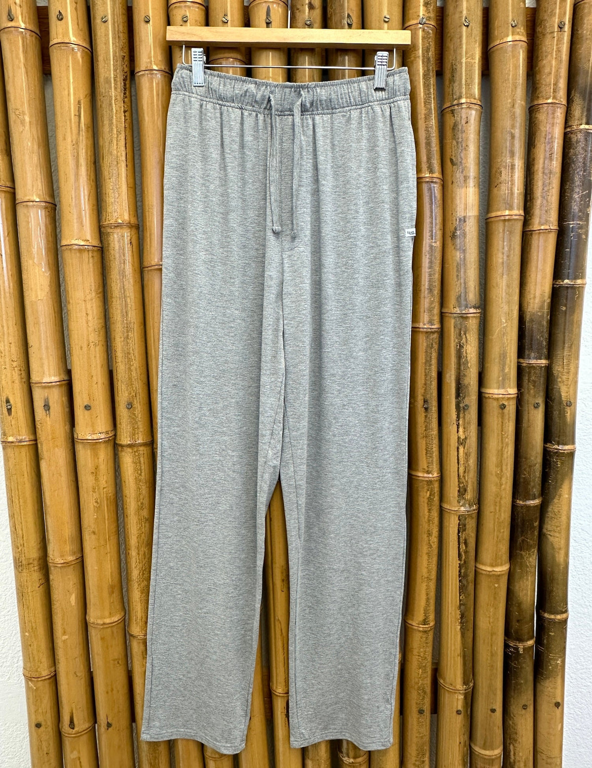 Spun Bamboo men's lounge pants in Heather Grey on a hanger, showing the elastic waist, drawstring and full leg length.
