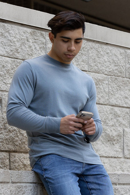 Spun Bamboo long-sleeve crewneck in Slate Grey, shown against a stone wall.