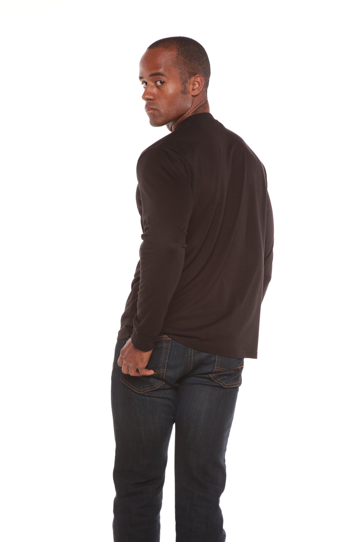 Rear three-quarter view of a dark Spun Bamboo long-sleeve crewneck, styled with jeans.