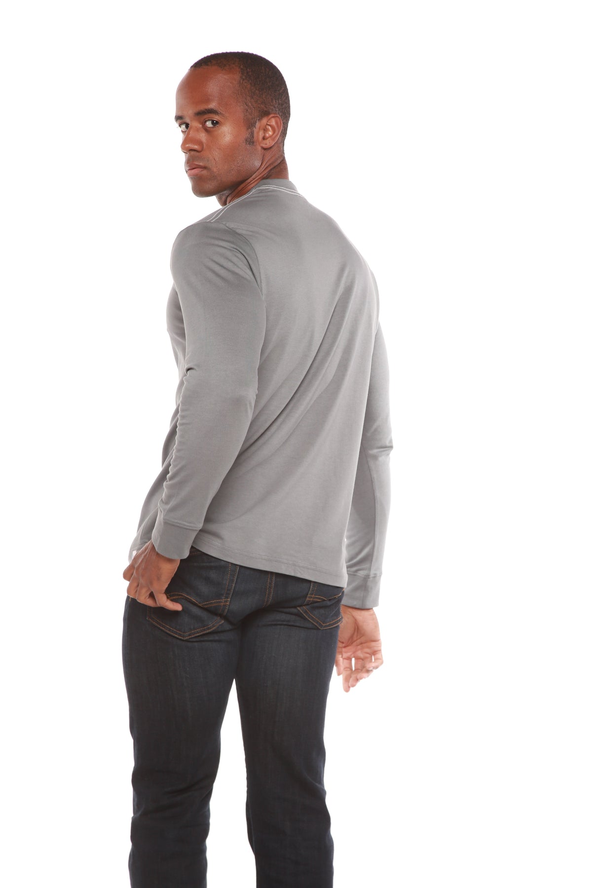 Rear three-quarter view of a grey Spun Bamboo long-sleeve crewneck, styled with dark jeans.